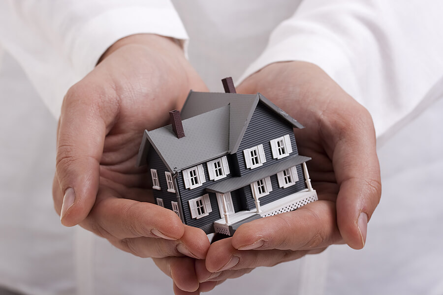 Picture of a home being held by hands representing homeowners insurance for felons.