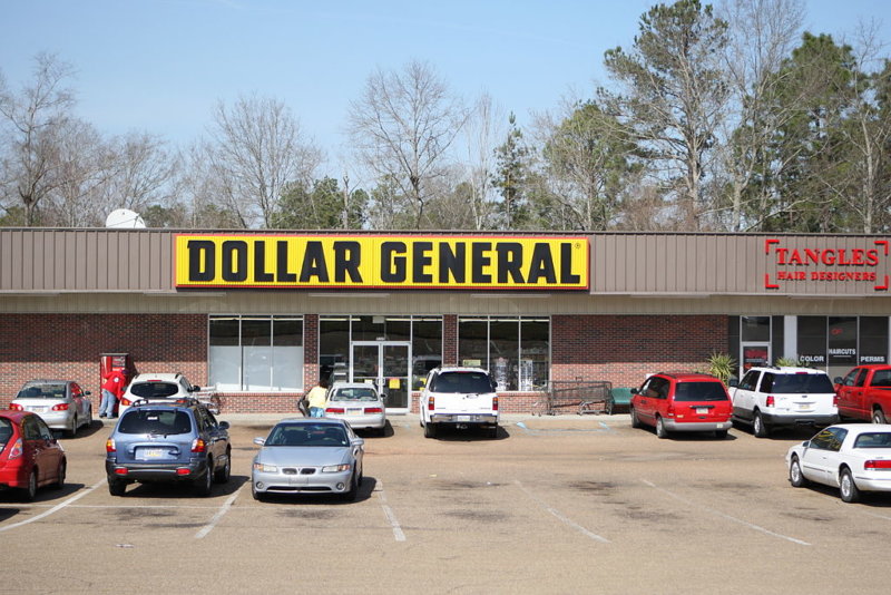 Image of a Dollar General Store. It shows the front of the building and the parking lot.